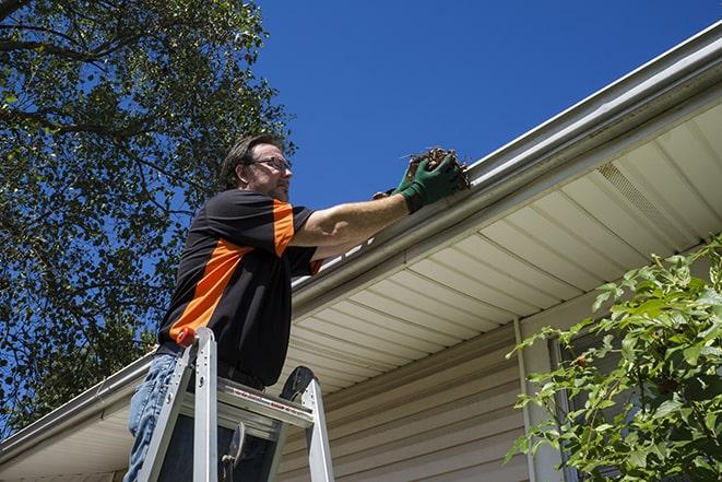 skilled worker repairing damaged gutter with tools in Aspen Hill